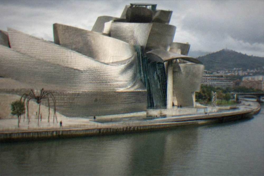 The titanium curves of the Guggenheim Museum beside the Bilbao estuary on a bright afternoon