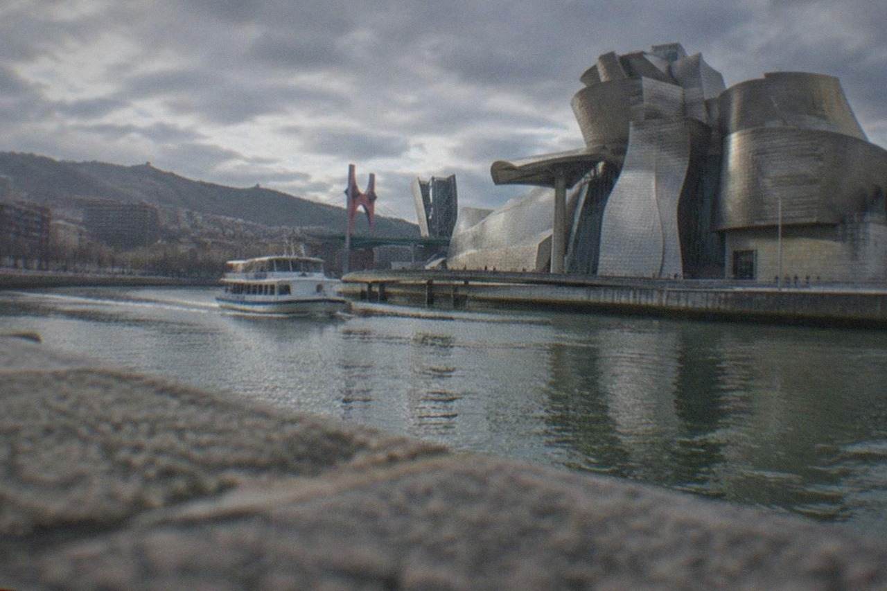 The Guggenheim Museum Bilbao beside the Nervion river on a bright day