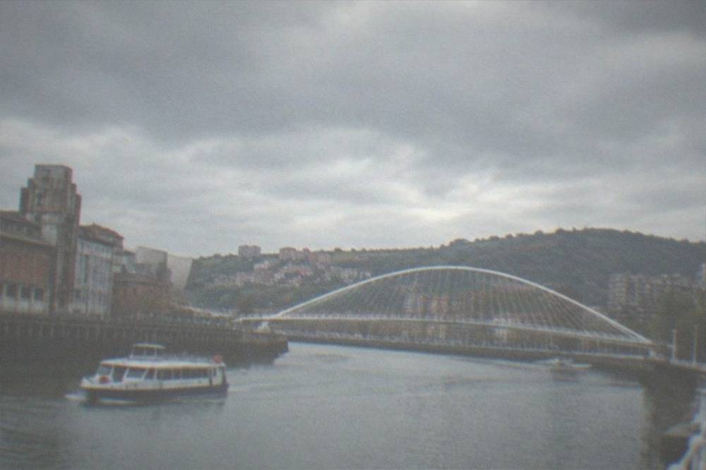 White curved footbridge spanning the Nervion river in Bilbao