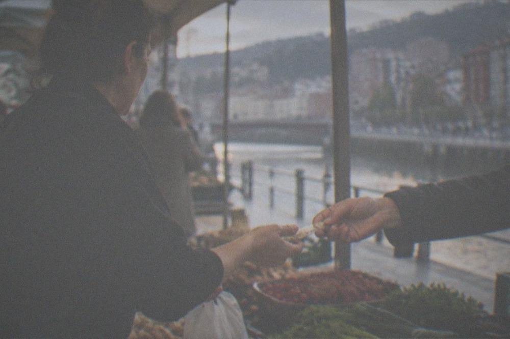 A market stallholder handing change to a customer at a food market in Bilbao