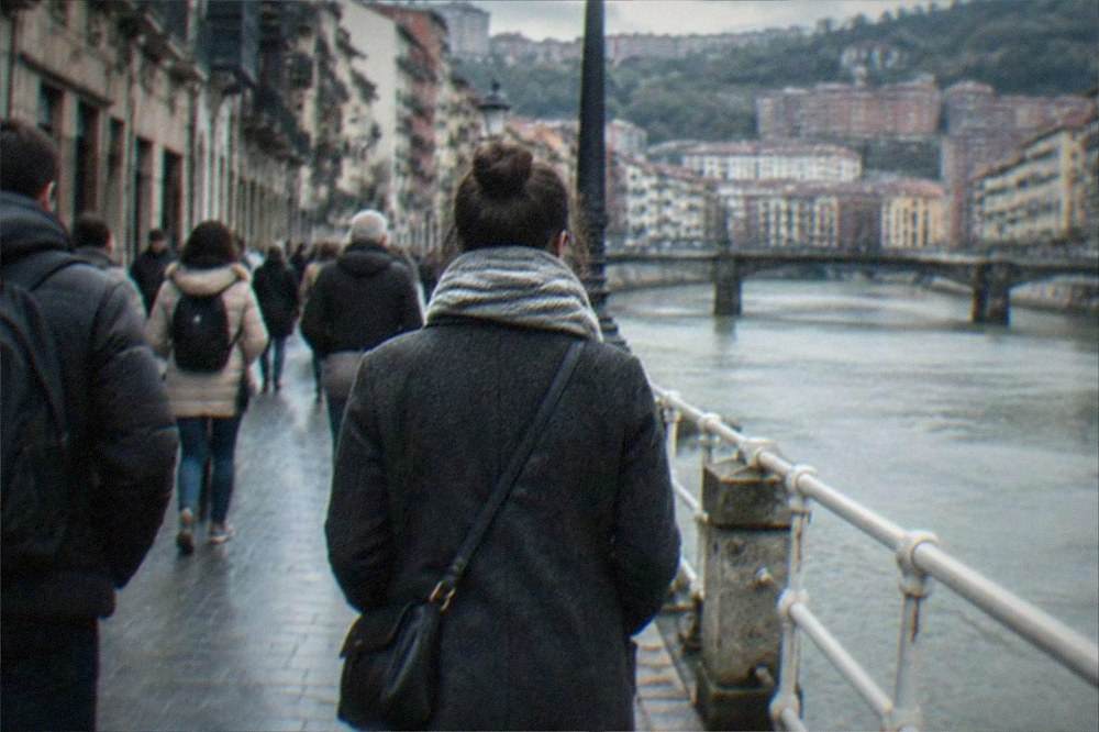 A visitor walking with a crossbody bag through a crowded old-town street in Bilbao
