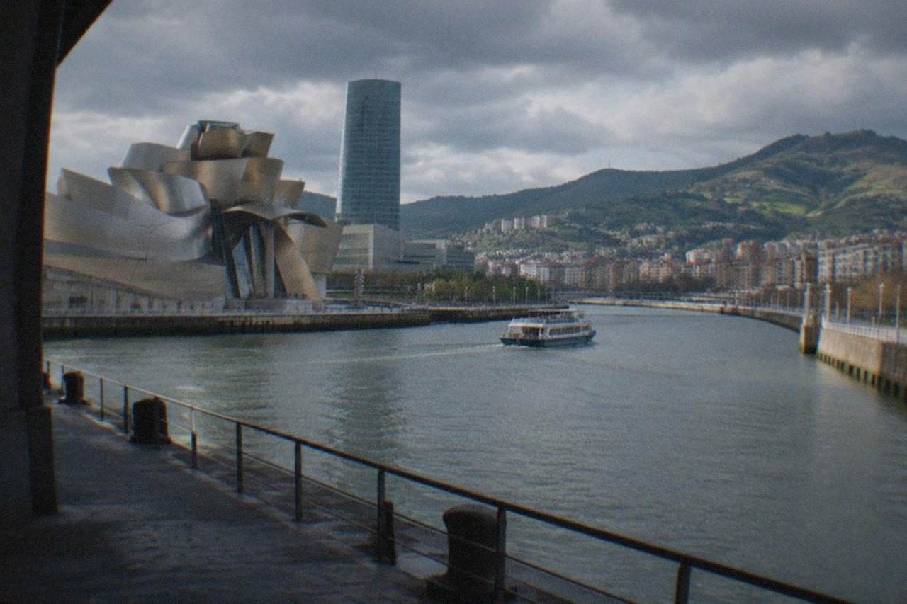 View over Bilbao with the Nervion estuary, the Guggenheim Museum and green hillsides under an Atlantic sky