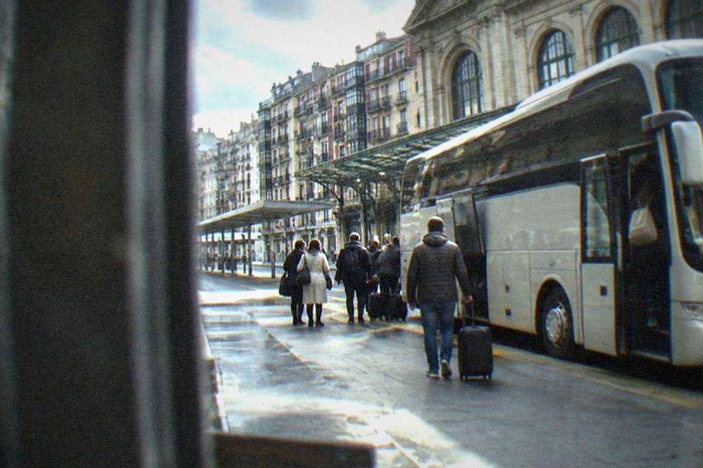 Long-distance coach parked at a platform with passengers boarding