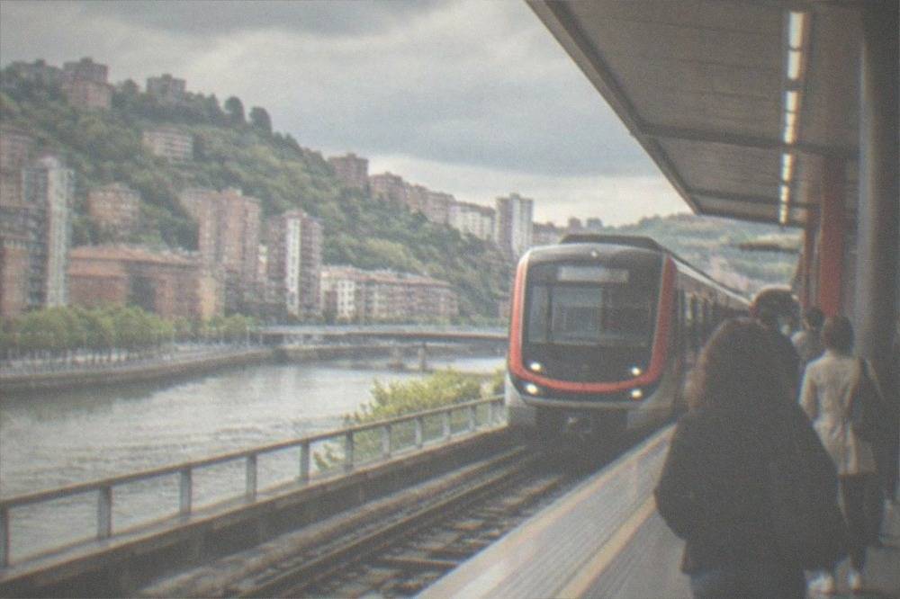 Bilbao metro station platform with a train arriving and passengers waiting