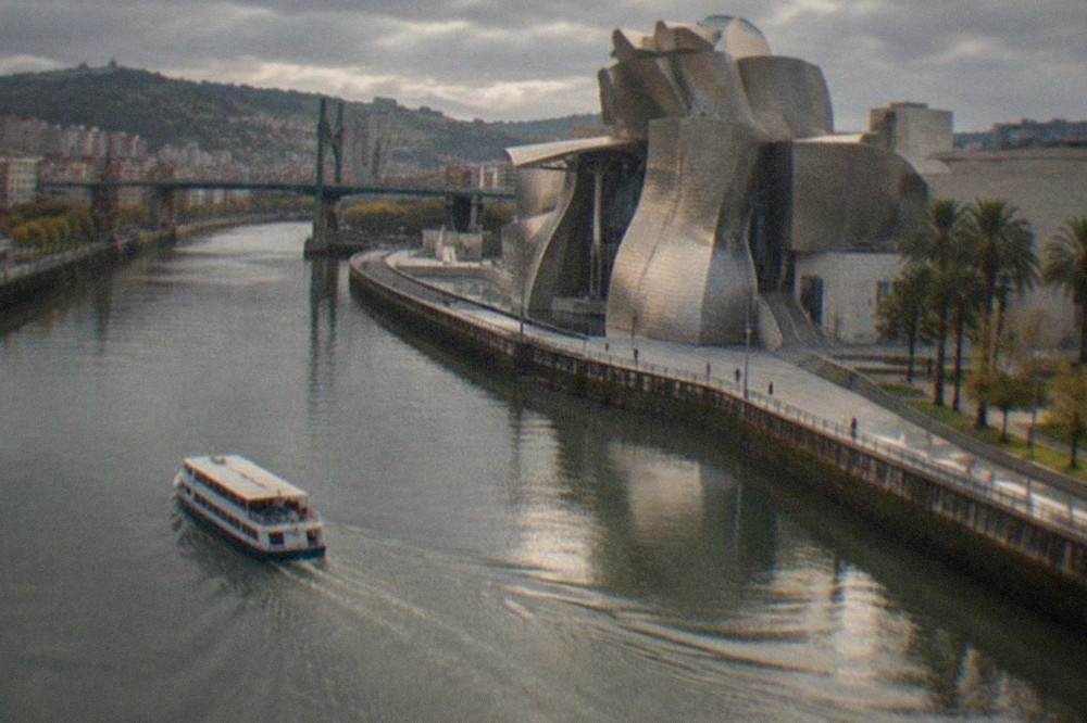 The Guggenheim Museum's titanium curves beside the Nervion river in the late afternoon