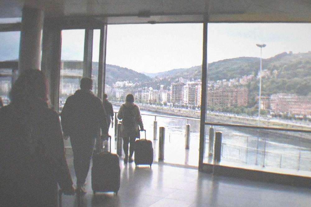 Departures hall of Bilbao Airport with travelers moving toward the exits