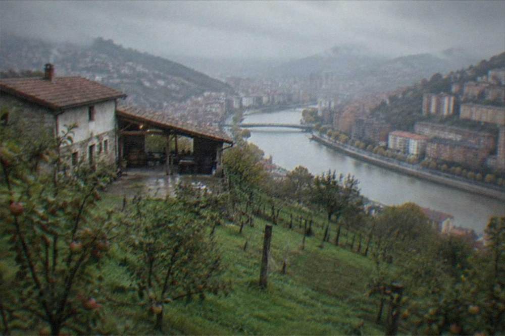 A rural Basque cider house building with apple orchards in the foreground on a misty day