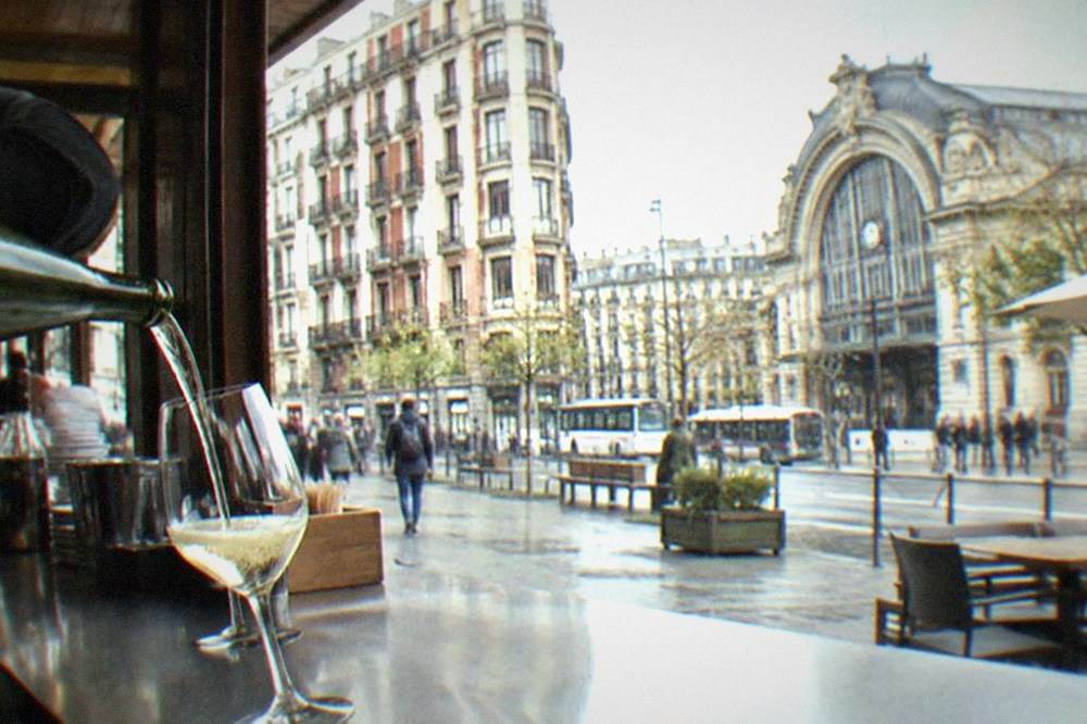 A glass of txakoli being poured behind a Bilbao bar counter in the morning