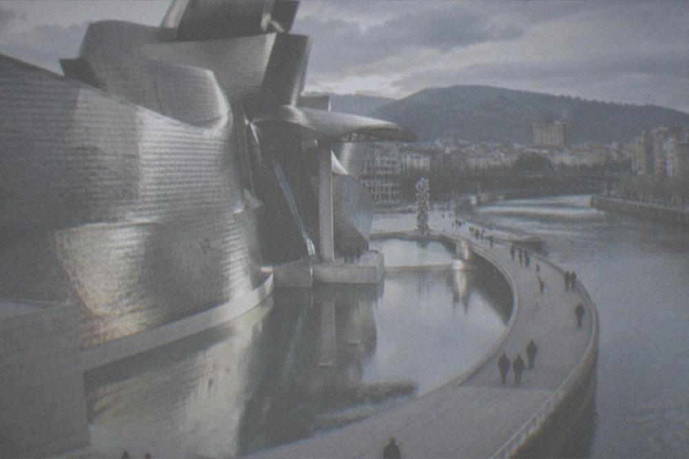 Visitors walking past the Guggenheim Museum on a clear morning in Bilbao