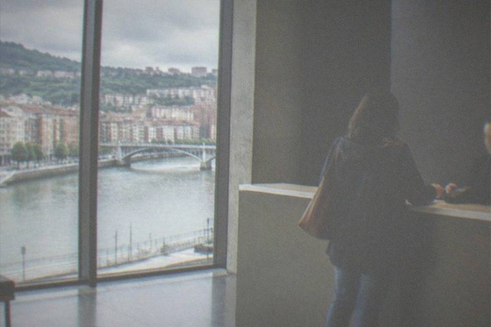 A museum ticket desk in Bilbao with a visitor paying by card