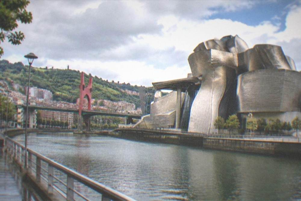 The Bilbao riverside with the Guggenheim Museum's titanium curves in the background on a bright day