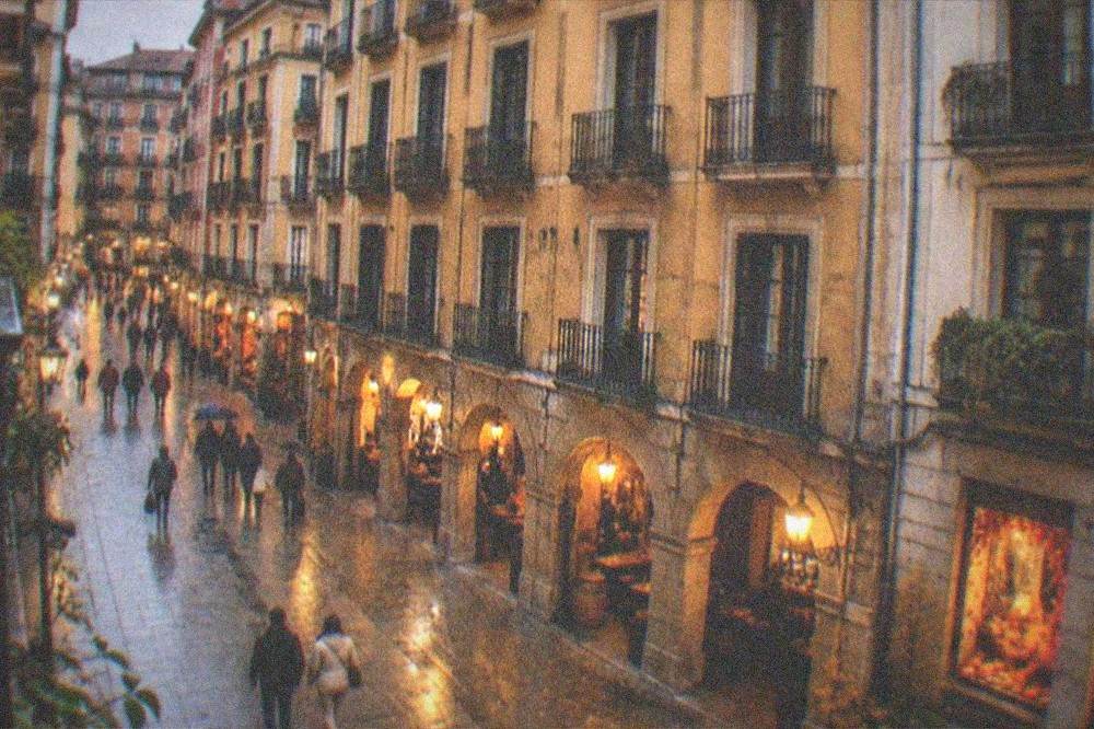 An evening view of Bilbao's illuminated Casco Viejo streets with autumn decorations in shop windows