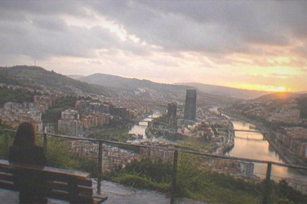 The Artxanda viewpoint above Bilbao at sunset with the city and estuary spread below under warm light