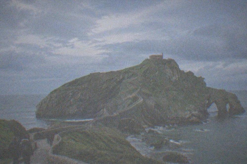 The stone causeway and steps leading to the hermitage of San Juan de Gaztelugatxe under a clearing spring sky