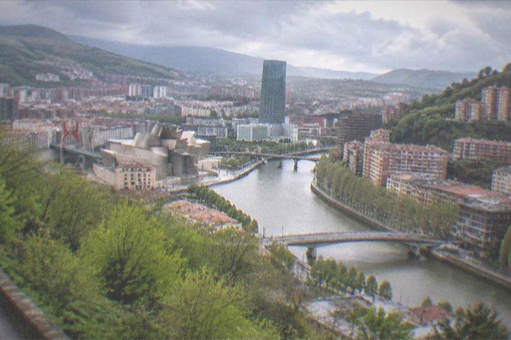 The Bilbao skyline seen from the Artxanda hillside viewpoint under a partly cloudy spring sky