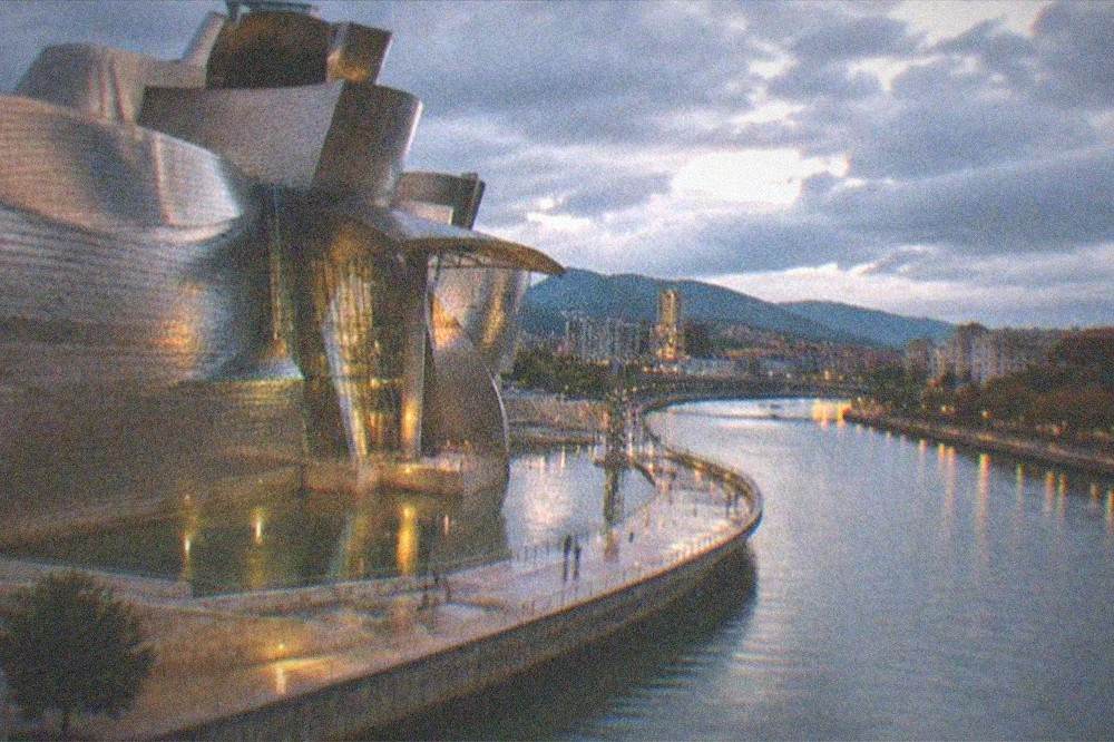 Evening view over Bilbao with the illuminated Guggenheim Museum and the river promenade
