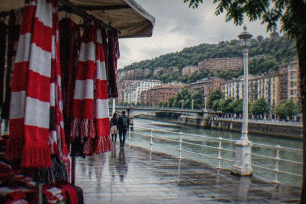 Red and white Athletic Club scarves hanging on a market stall in central Bilbao