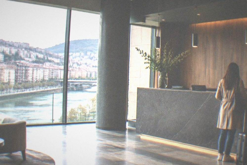 A modern hotel reception desk in Bilbao with a guest checking in