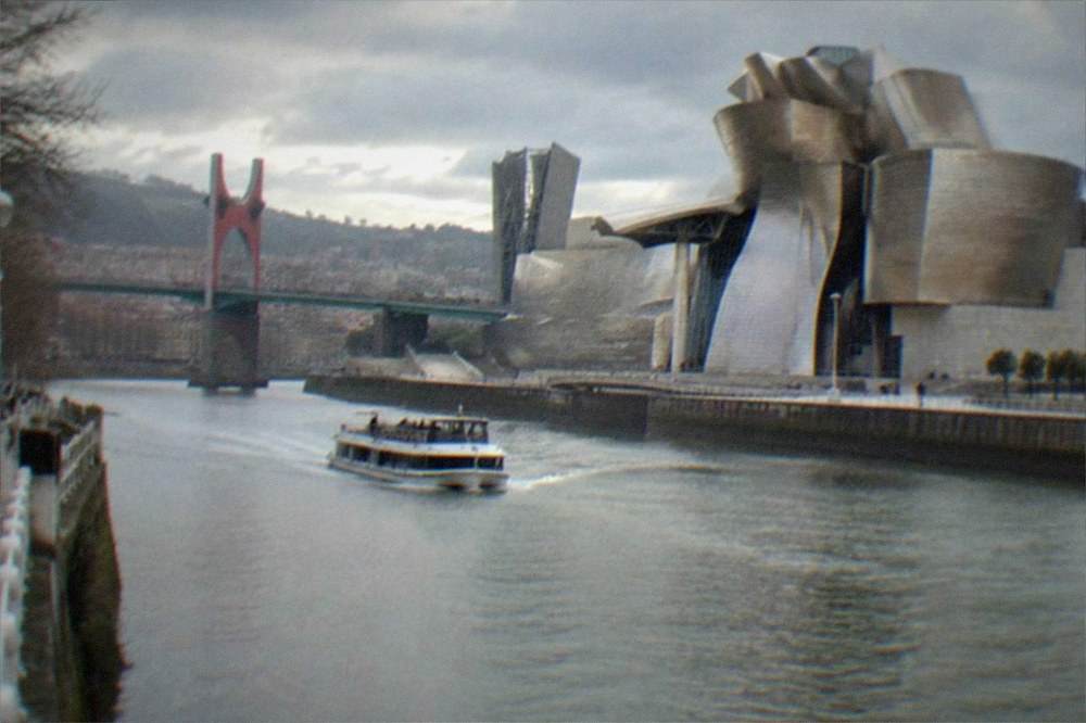 The titanium curves of the Guggenheim Museum beside the Nervion river on a bright afternoon