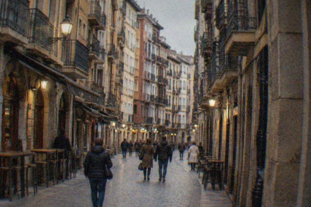 People walking through the narrow Siete Calles streets of Bilbao's Casco Viejo in the evening