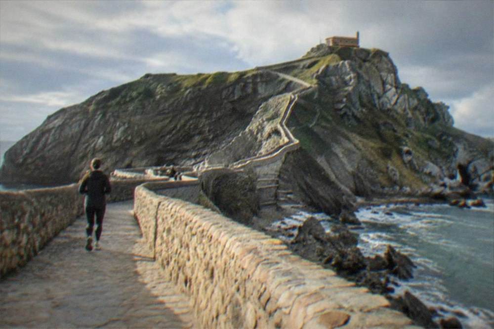 The rocky islet of San Juan de Gaztelugatxe with its stone causeway and hermitage under a blue sky
