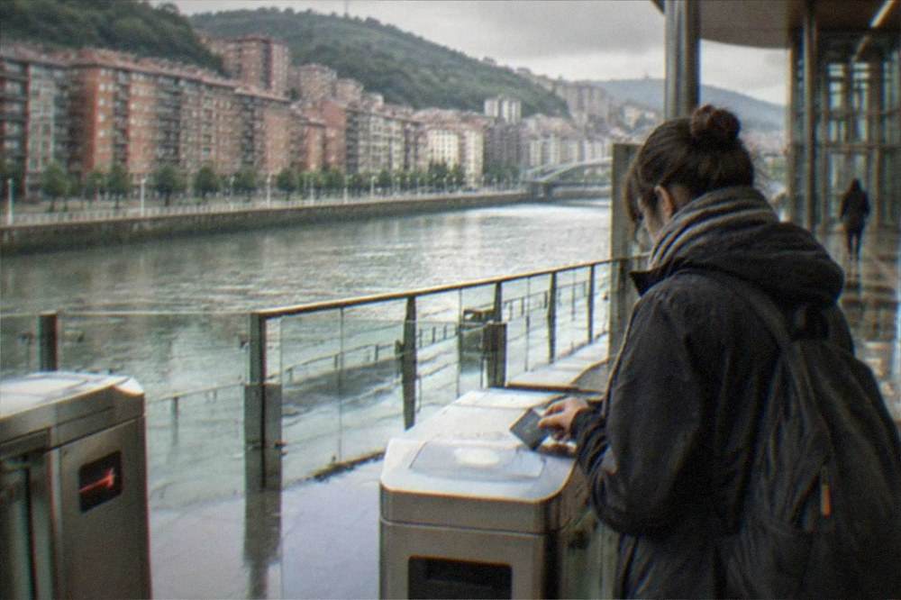 A traveler tapping a transit card at a metro station gate in Bilbao