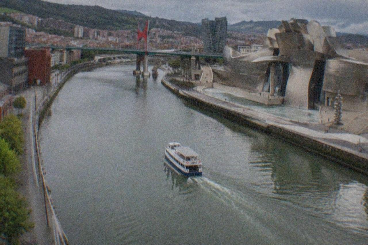 The Guggenheim Museum Bilbao's titanium curves beside the Nervion estuary at dusk