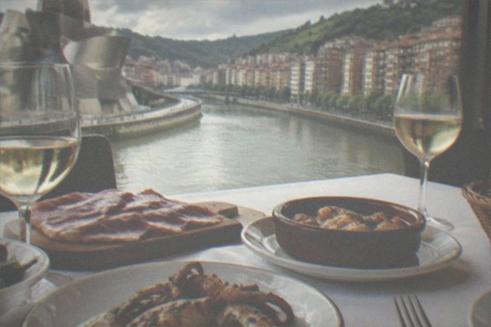 A white tablecloth dining room with Basque tasting plates being served in a Bilbao restaurant