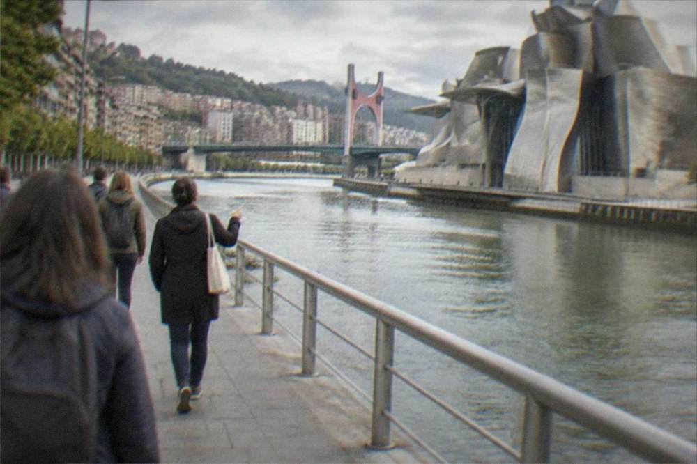 A private guide leading a small group along the riverside promenade toward the Guggenheim Museum in Bilbao