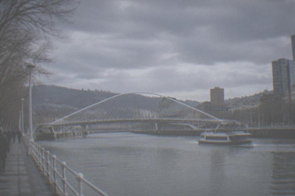 The Nervion river walk in Bilbao with the Zubizuri bridge on a calm winter morning