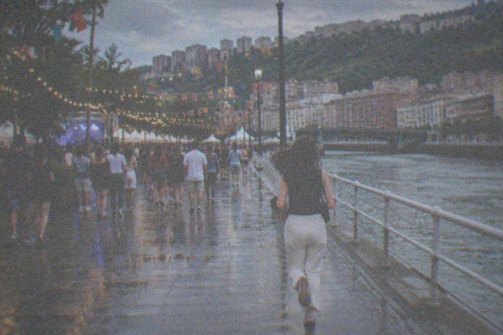 Crowds and colourful festival decorations in a Bilbao square during a summer evening