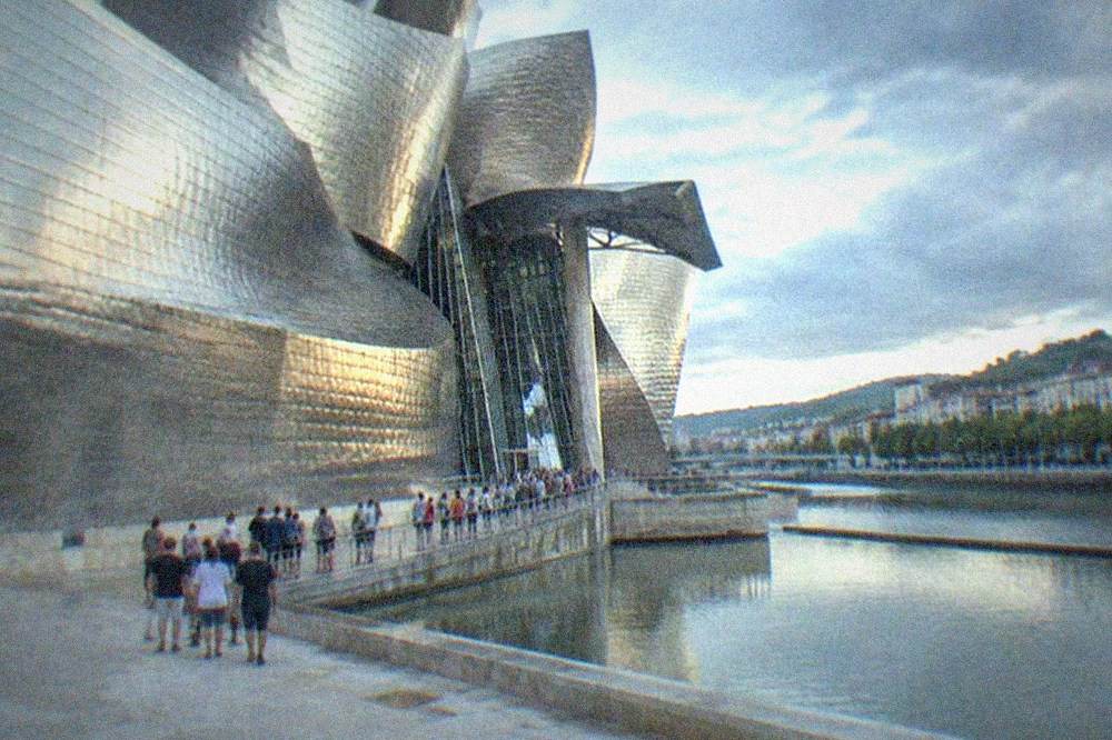 Visitors queuing at the titanium-clad entrance of the Guggenheim Museum Bilbao on a summer afternoon