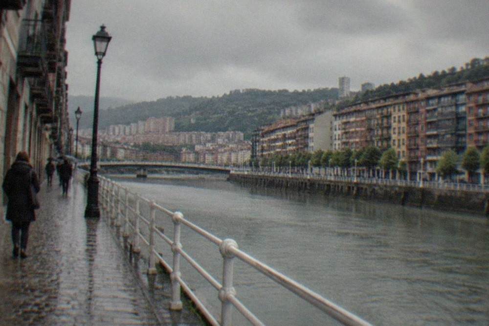 Rain-slicked cobblestone street in the Bilbao old town under grey Atlantic sky