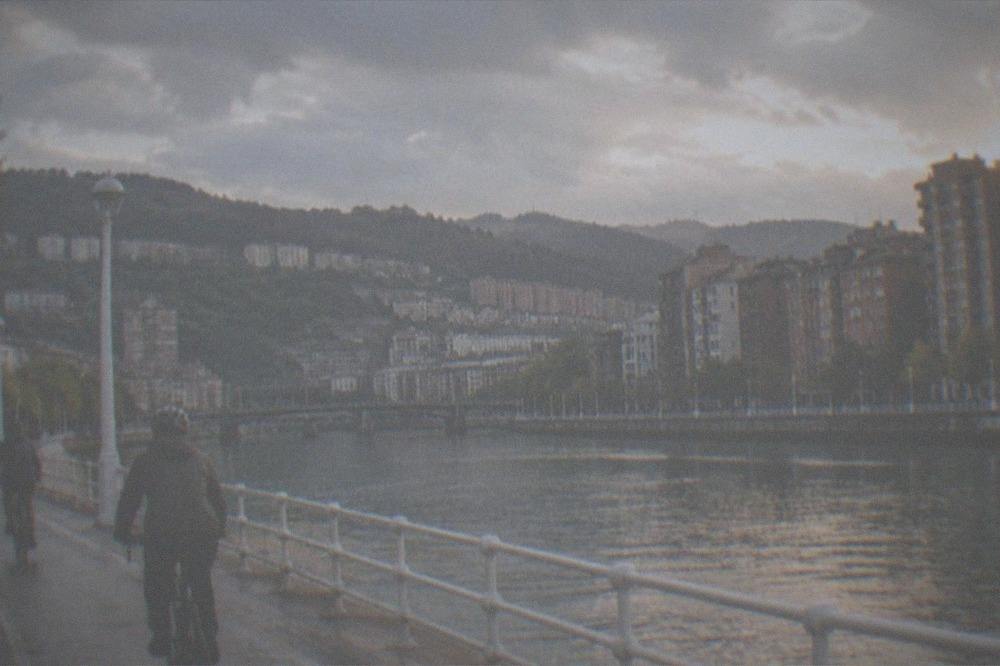 Cyclists riding along the riverside path beside the Bilbao estuary
