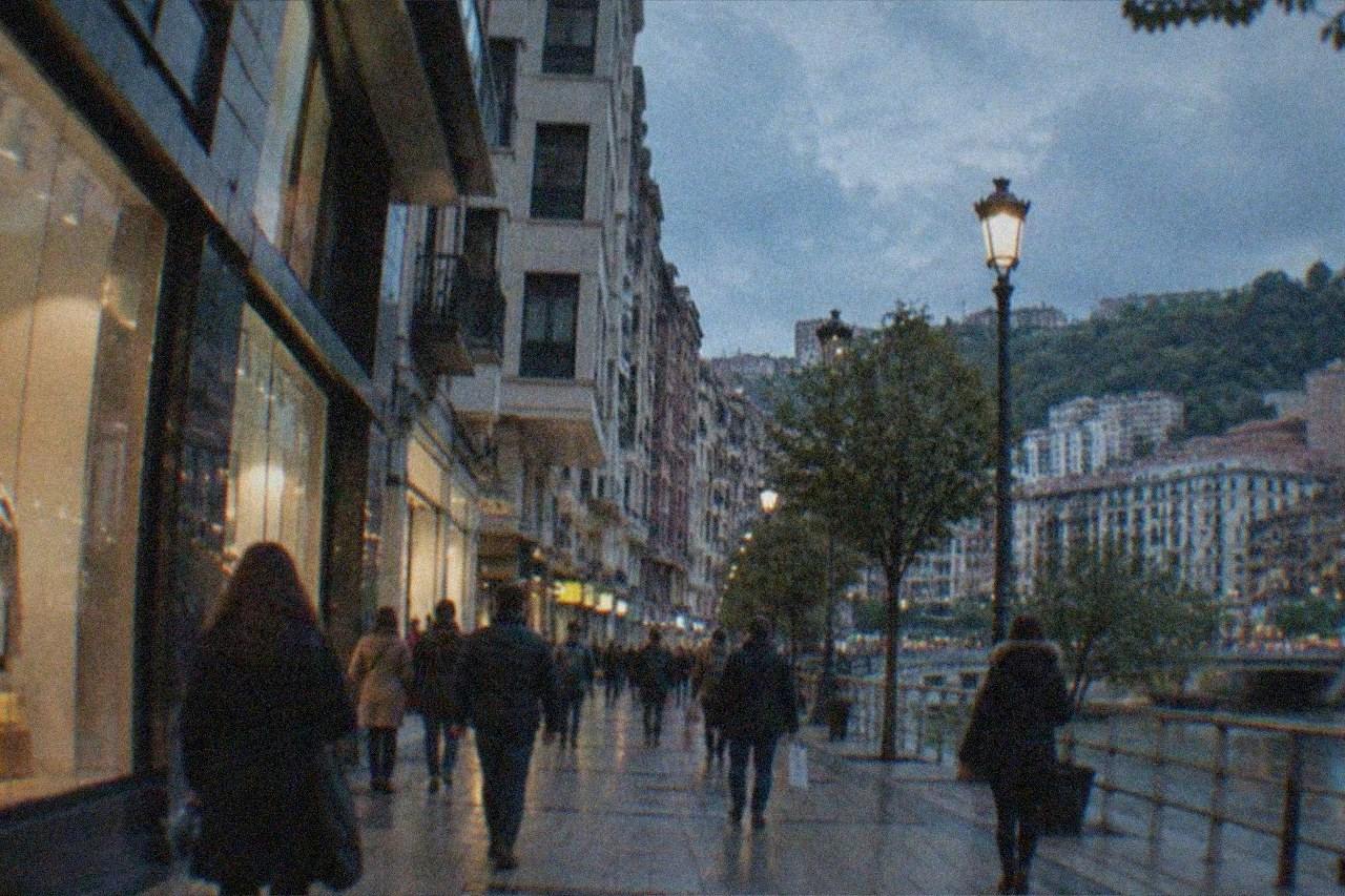 Shoppers walking past storefronts on a busy pedestrian shopping street in central Bilbao