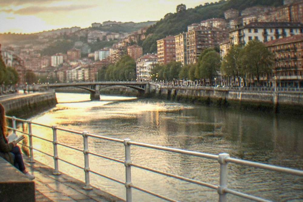 A single traveller reading a map on a bench near Moyúa square in central Bilbao