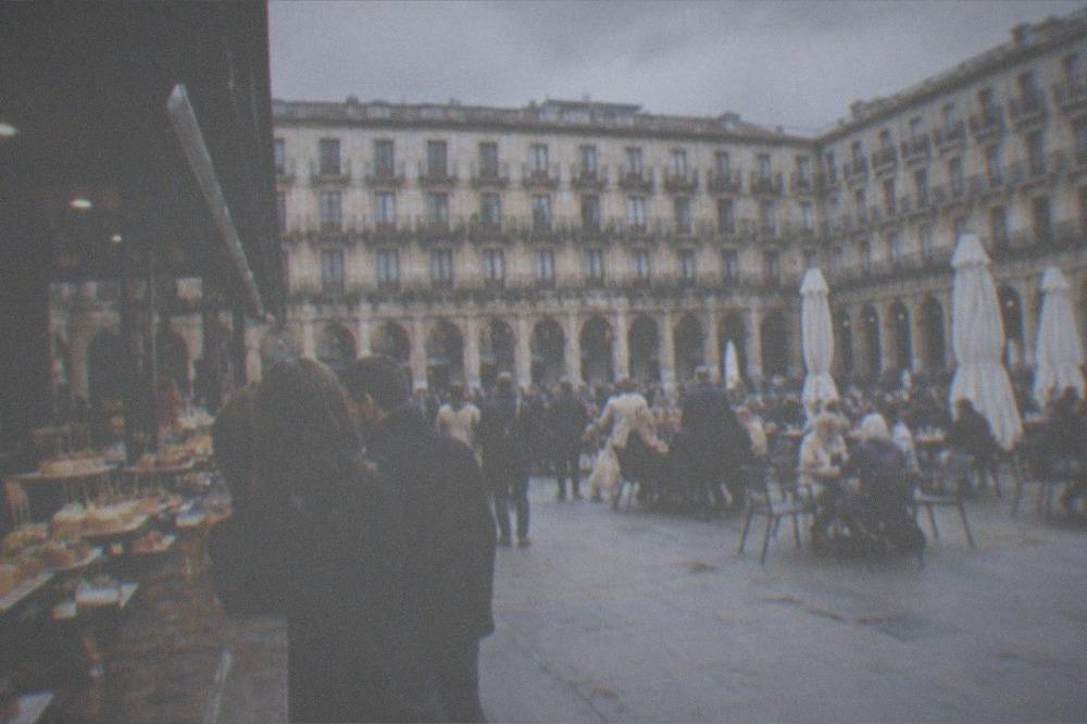 A crowded pintxos bar counter in Plaza Nueva with small plates on display