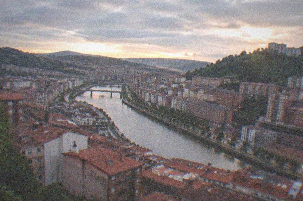 An evening view over Bilbao rooftops with the river running between the districts