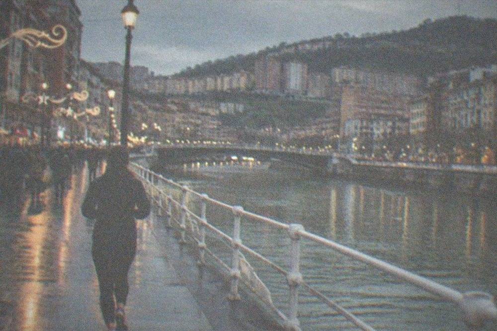 Evening crowd on a lit Bilbao street with festival decorations and music