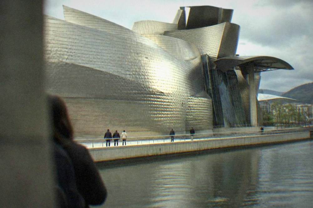 Visitors walking beside the titanium curves of the Guggenheim Museum in Bilbao