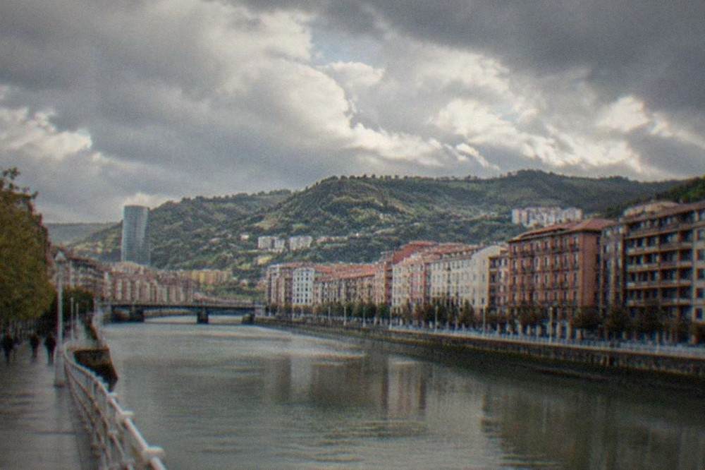 Green hills above the Bilbao estuary under grey Atlantic clouds