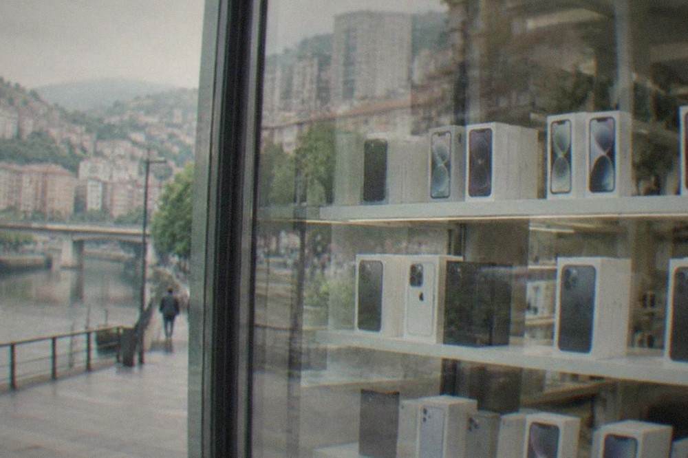 A phone shop window display in central Bilbao with smartphone boxes on shelves