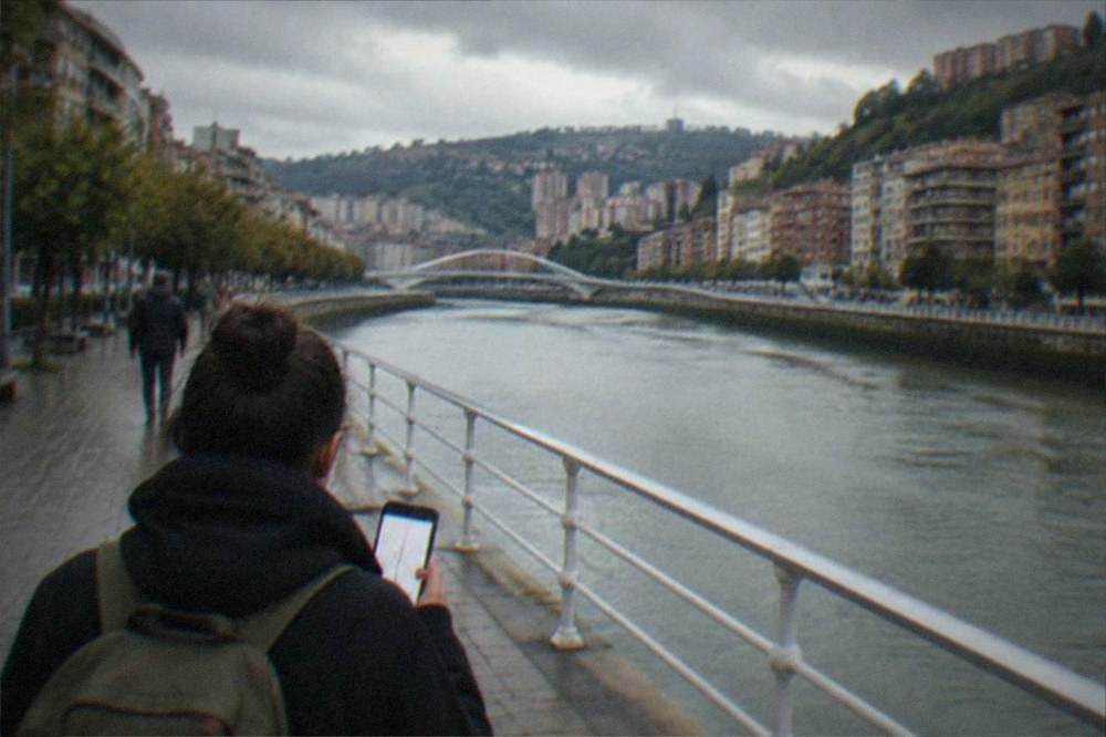 A traveler holding a phone showing a metro map inside a Bilbao metro station