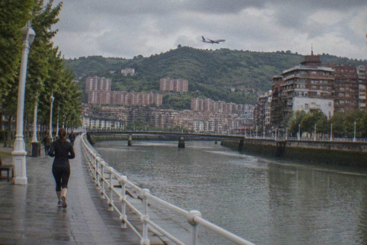 A passenger aircraft descending over green hills toward a regional airport in northern Spain