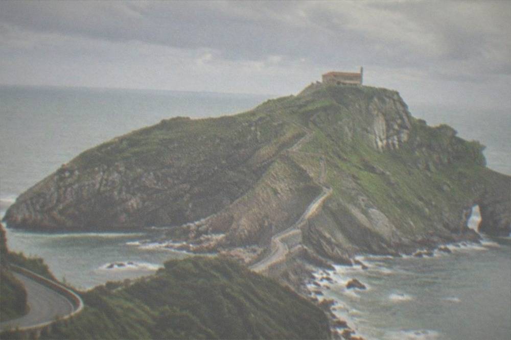 A coastal road winding along green cliffs above the Bay of Biscay in northern Spain