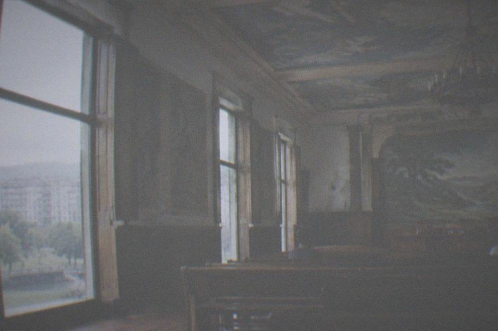 A ceremonial hall with wooden benches and a painted ceiling inside the Gernika Assembly House
