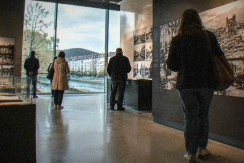 Visitors walking through a modern museum gallery with photographs and displays about the history of Gernika