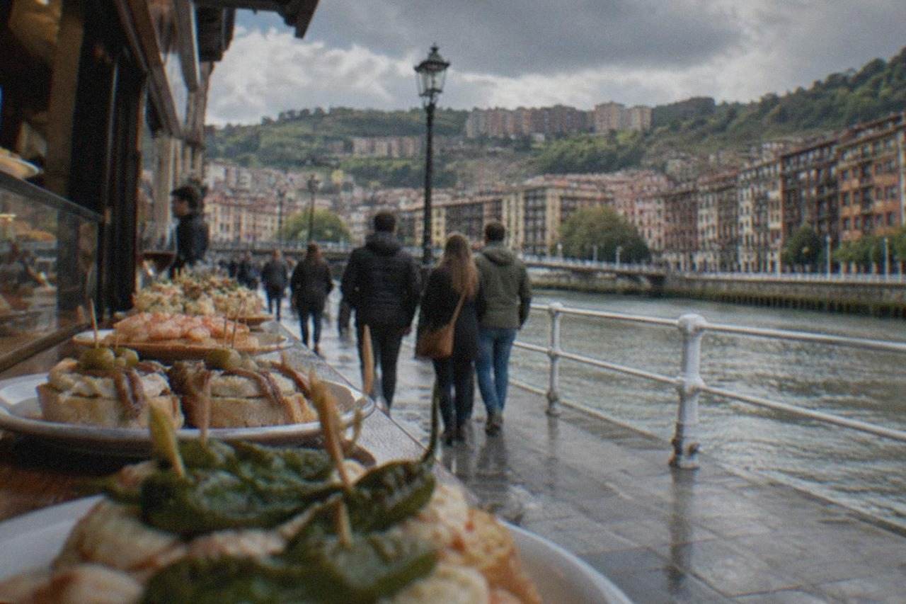 Visitors walking past pintxos bars with counters of food in Bilbao's Old Town