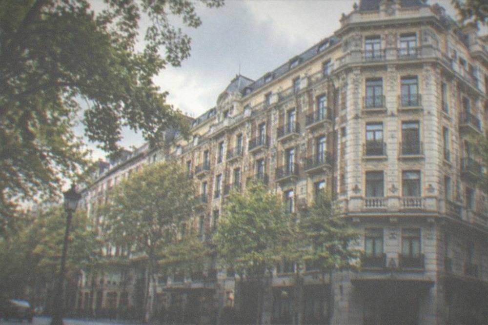 Grand facade of a hotel building on a tree-lined Ensanche street in Bilbao