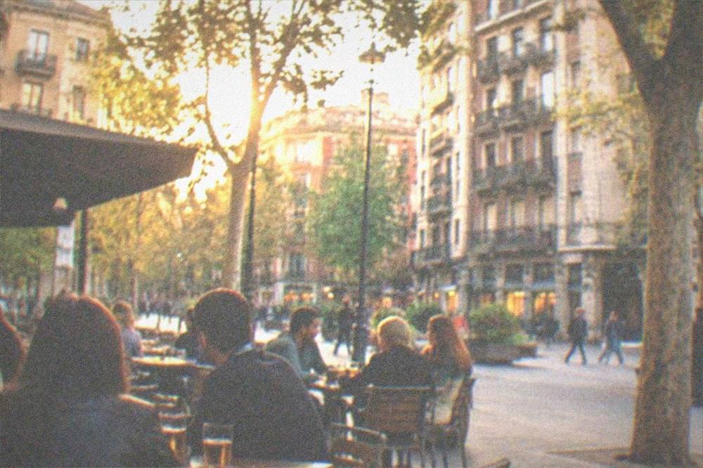Evening street scene in Indautxu with people at outdoor bar tables in Bilbao